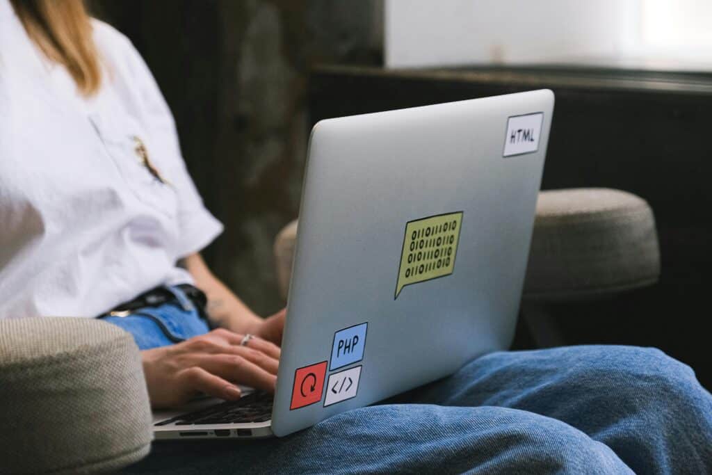 Person working on a laptop with AI-related stickers, representing AI for tax preparation services