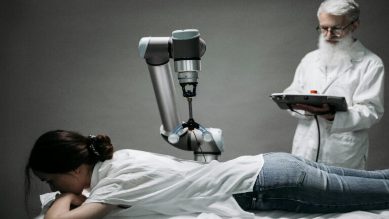 A robotic arm performing a procedure on a patient supervised by a technician.