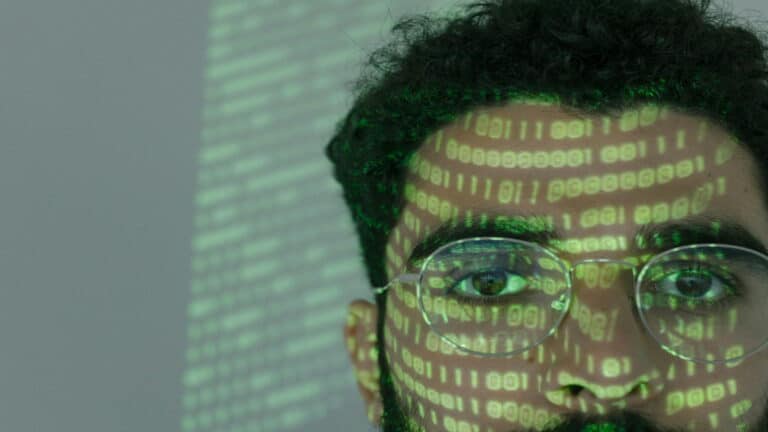 Close-up of a person with binary code projected on their face