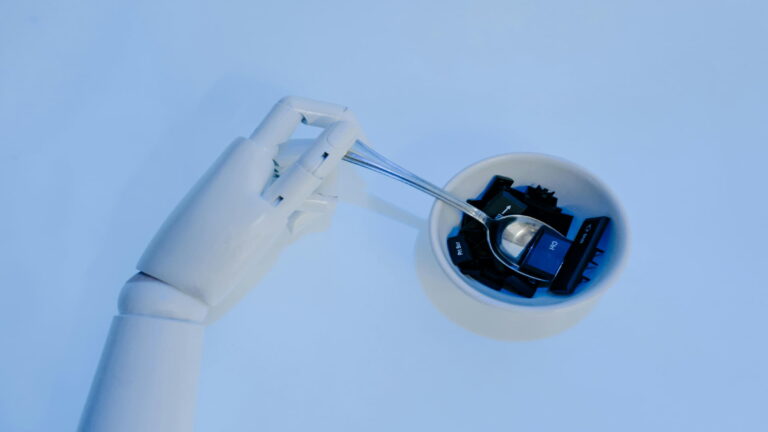 Robotic hand holding a spoon with keyboard keys