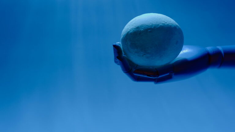 A robotic hand holding a spherical object against a blue background