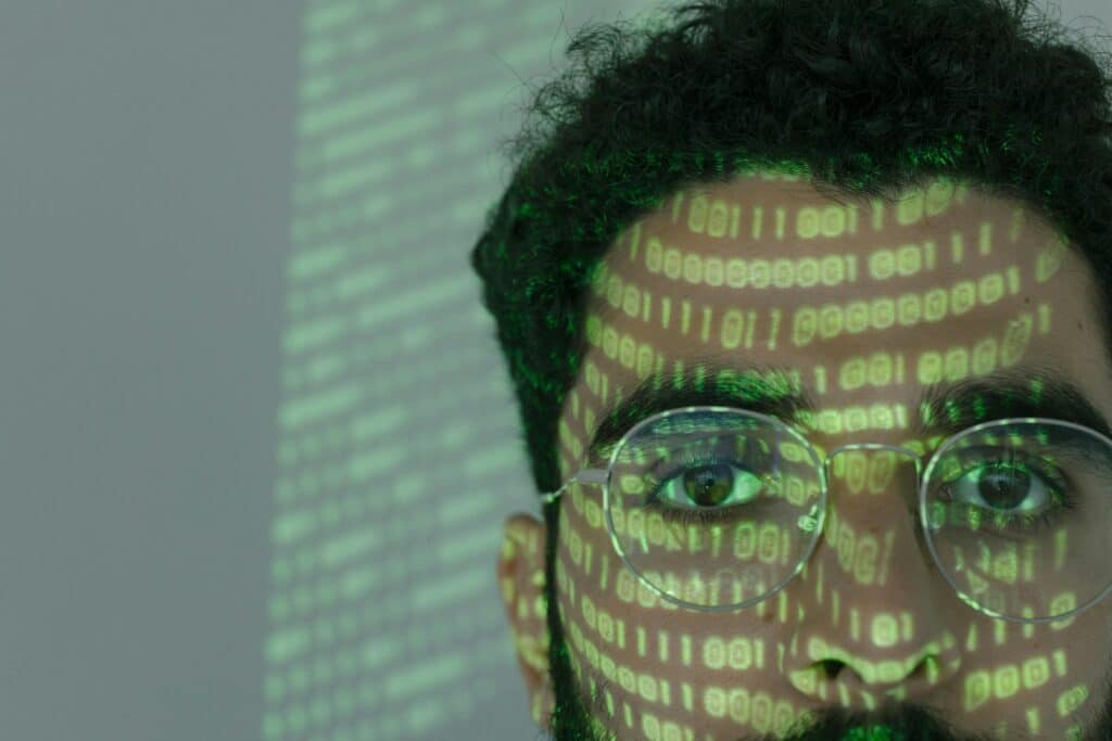 Digital binary code projected on a person's face symbolizing AI for orthopedic services