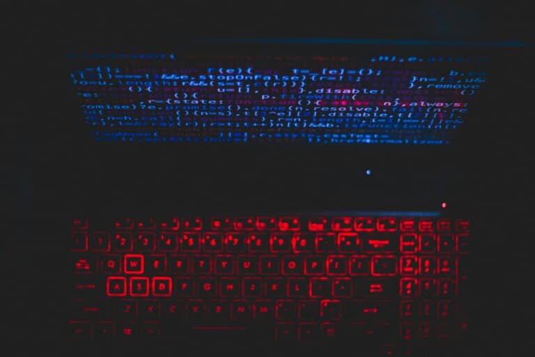 Red illuminated keyboard displaying code, symbolizing AI for Courier and Delivery Services integration for AI Implementation in the UK.